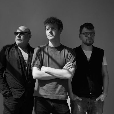 Black and white image of the Fabian Willmann Trio standing smiling next to one another